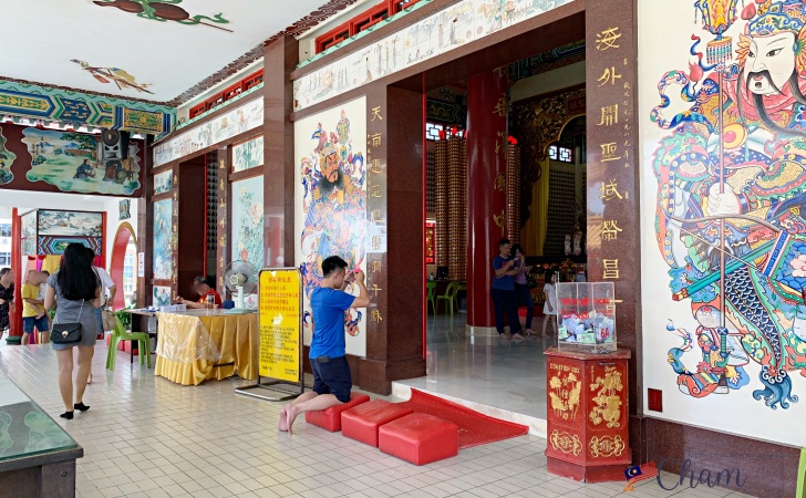 クアラルンプールの天后宮（Thean Hou Temple）の本殿前でお線香を持ってお参りしている男性