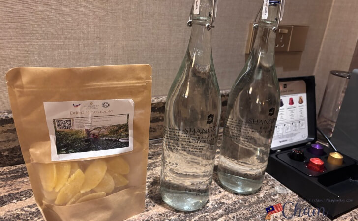 シャングリ ラ ラサリア コタキナバルの客室にある水とドライパイナップル