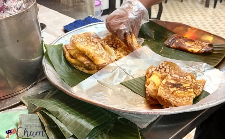 バナナの葉の上に置いて提供されるRavi's Claypot Appom Manisのアポンマニス